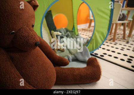 Cute bear toy on floor in child room Stock Photo