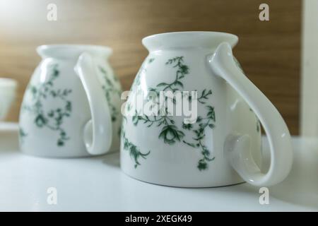 Set of clean mugs in kitchen cupboard, upside down Stock Photo