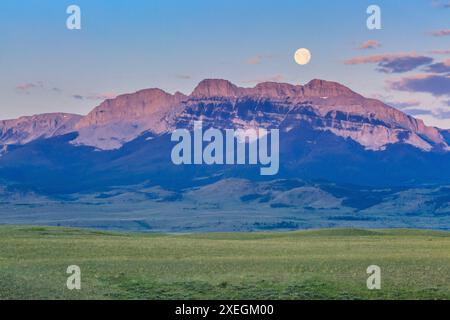 full moon setting over sawtooth ridge along the rocky mountain front near augusta, montana Stock Photo