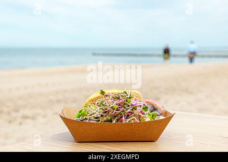 Fish roll in sandwich box on a table on a beach. fillings in paper ecological boxes craft. Tradition Stock Photo