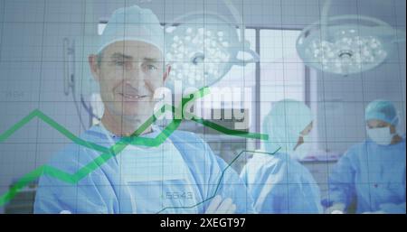Image of statistical data processing over caucasian male surgeon smiling in operation theatre Stock Photo