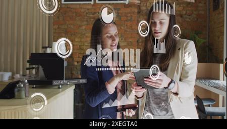 Image of statistical data processing over two caucasian women discussing over digital tablet Stock Photo