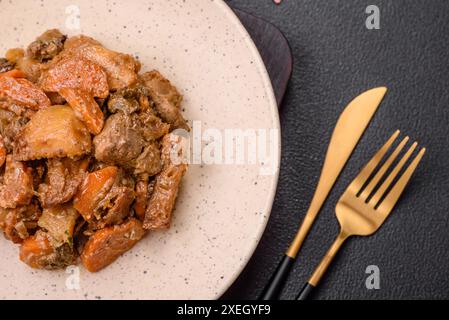 Delicious vegetable stew of potatoes, beef meat, mushrooms, carrots, salt, spices and herbs Stock Photo