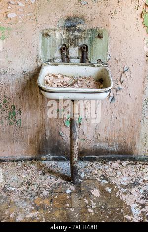 Old Abandoned Grunge Metal Sink On Pink Peeling Pain Wall Background Stock Photo