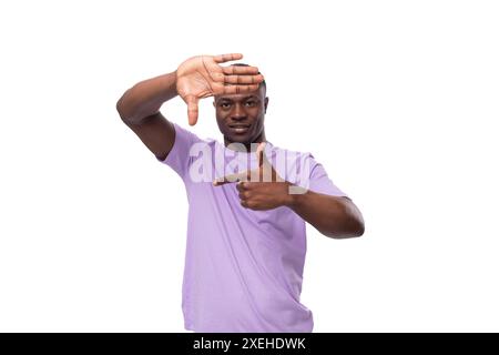 A young friendly well-groomed american guy dressed in a cotton t-shirt shows a frame with his hands Stock Photo