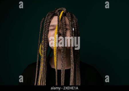 Woman With Long Dreadlocks in Front of Green Background Stock Photo