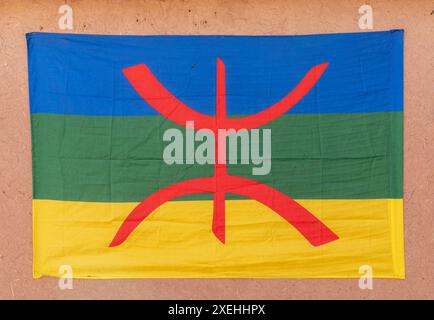 Close-up view of a Berber flag with the free man symbol hanging from an adobe wall in the Moroccan desert Stock Photo