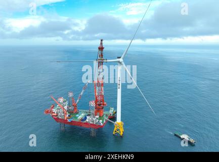 (240628) -- ZHANGZHOU, June 28, 2024 (Xinhua) -- An aerial drone photo taken on June 19, 2024 shows workers installing the blade of a 16-megawatt wind turbine of the phase II project of Zhangpu wind farm in southeast China's Fujian Province. The phase II project of Zhangpu wind farm, China's first offshore wind farm with the largest single-capacity with turbines, was connected to the grid for power generation on Thursday. The project is located about 30 kilometers from the coastline of Zhangpu County in Fujian, and built by China Three Gorges Corporation. With a total installed capacity of Stock Photo