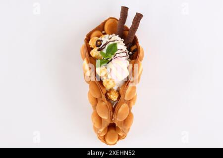 Trendy Hong Kong bubble waffles with ice cream, cream and berries on white wooden background. Copy space Stock Photo