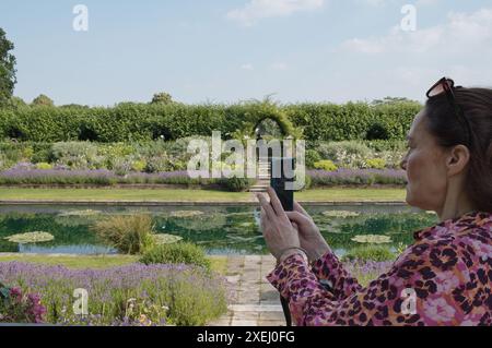 Woman tourist visiting the Diana Princess of Wales Memorial Garden in Kensington Palace, London in Summer Stock Photo