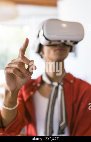 Using VR headset, young man interacting with virtual environment at home Stock Photo