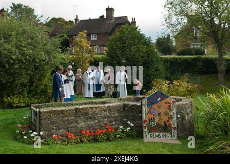 Well Dressing Kent. St Mary's Church Kemsing was the birthplace in AD961 of Saint Edith of Wilton an illegitimate daughter of the Saxon King Edgar I. The pilgrimage to the Well at the centre of the village which is dressed every year with a single Well Dressing plaque is unveiled during a short service. The Well is dedicated to her saintly presence; the Well water has healing properties. Kemsing, Kent, England 13th September 2014. 2010s UK HOMER SYKES Stock Photo