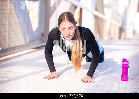 Active runner doing warm-up push-ups for running or cardio. Stock Photo