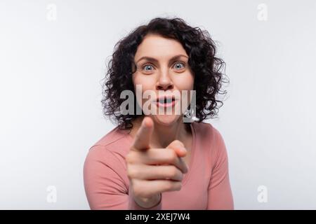 Inspired brunette curly woman holding thumbs up Stock Photo