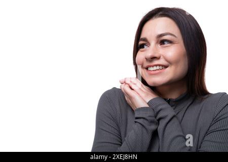 Casual young brunette woman wearing a marsh-colored turtleneck on a white background, close-up Stock Photo