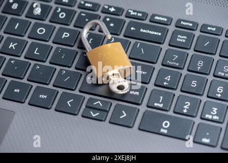 Open lock with key on computer keyboard Stock Photo