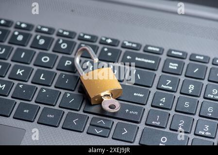 Open lock with key on computer keyboard Stock Photo
