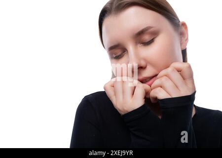 European dreaming schoolgirl wearing a black turtleneck on a white studio background Stock Photo