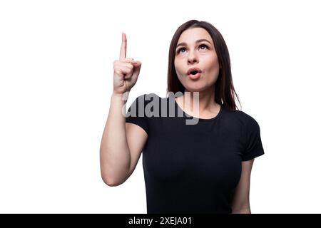 Young slim brunette woman inspired by an idea and holding a thumbs up Stock Photo