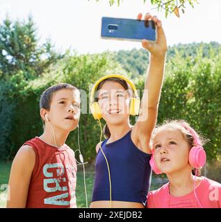 portrait of three boys in sportswear standing taking a selfie Stock Photo