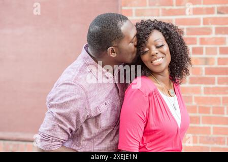 Man kissing woman on the head while she is smiling Stock Photo