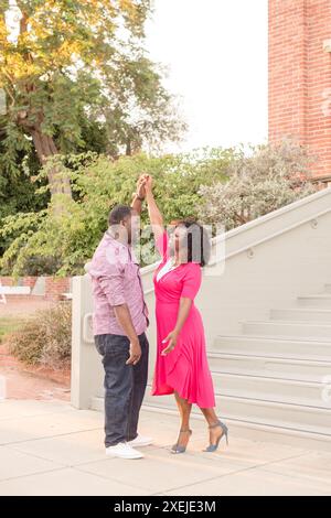 Couple holding hands in the air after walking down steps Stock Photo