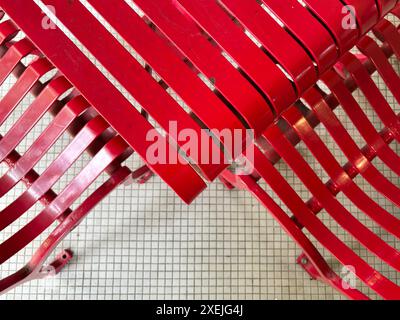 Red lacquer metal outdoor table and chairs on white square tiles Stock Photo