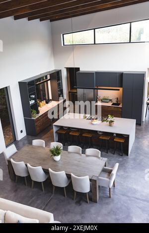 Modern kitchen and dining area with large table and stylish decor in home, copy space Stock Photo