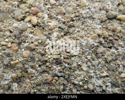 Texture of small sea pebbles. Natural stone seamless background. Rough surface of pebble stone. Top view, soft daylight. Stock Photo
