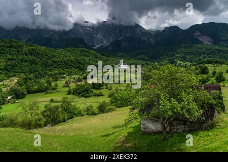 Idyllic Dreznica Village and Towering Mount Krn in Scenic Slovenian Landscape Stock Photo