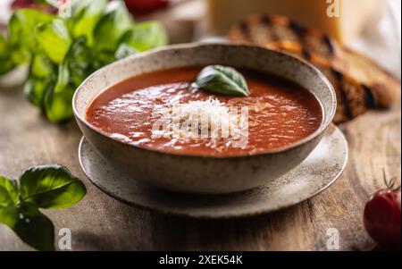 Healthy vegetarian tomato soup with parmesan and basil. Italian and Mediterranean food. Stock Photo