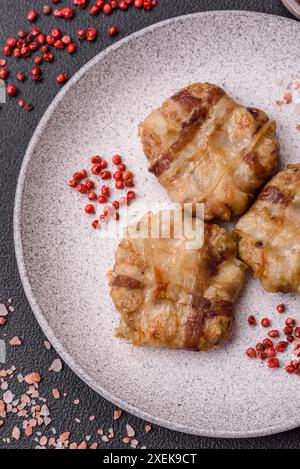 Round minced chicken or pork cutlet wrapped in bacon with salt Stock Photo