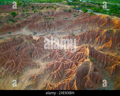 Aerial view of the Tatacoa desert in Colombia, showcasing its striking red rock formations and unique eroded landscapes bathed in sunlight. Stock Photo