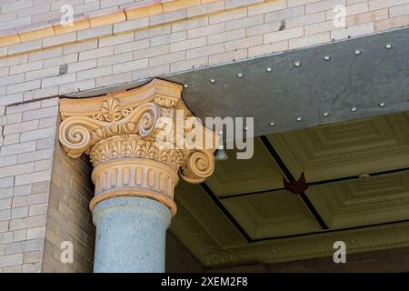 Close up of corinthian capitol on granite column in brick building facade Stock Photo