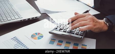 Financial and budget planning with chart report. Man using calculator Stock Photo