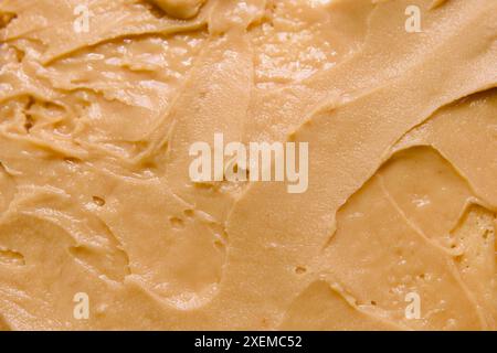 A detailed close-up of peanut butter in a swirl pattern, showcasing its smooth and creamy consistency Stock Photo