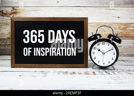 365 days of inspiration quotes text message and alarm clock on wooden background Stock Photo