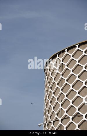 A futuristic cylindrical building exquisitely decorated with metal architectural elements. Stock Photo