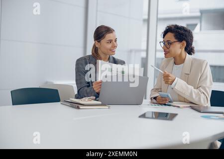Two female professional executives experts discussing financial accounting papers working together Stock Photo