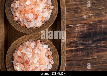 Himalayan salt in wooden bowls on wooden background. Top view Stock Photo
