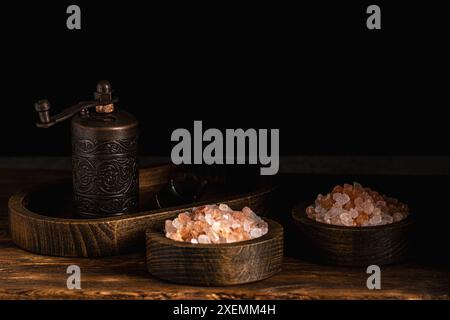 Himalayan pink salt in wooden bowl on black background Stock Photo