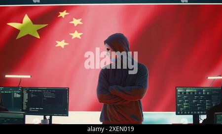 Chinese anonymous hackers group supervises criminal activity and propaganda in Chinese cybersecurity center with the national flag. Spreading fake news about the autocracy and dictatorship. Camera B. Stock Photo