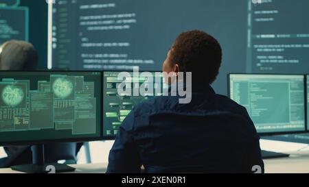 Governmental hackers analyzing big data for cyber threat detection, working at agency desks. Professional expert woman analyzes cyber intelligence and prevention of digital threats. Camera A. Stock Photo