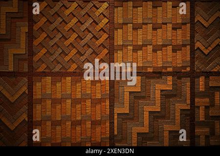 A photo of a wall designed with different colored bricks combined in various shapes for background material Stock Photo