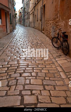 Cobblestone street in the old town of Rovinj, Croatia, with a bicycle parked against a wall; Rovinj, Istria County, Croatia Stock Photo