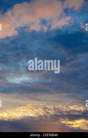 Clouds in a sky backlit by sunset light, showing various cloud formations and colours Stock Photo