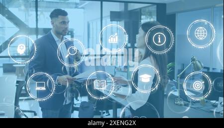 Image of icon in circles over diverse coworkers sharing ideas in office Stock Photo