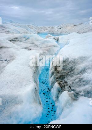 Drainage system on the surface of the ice sheet. Brown sediment on the ...