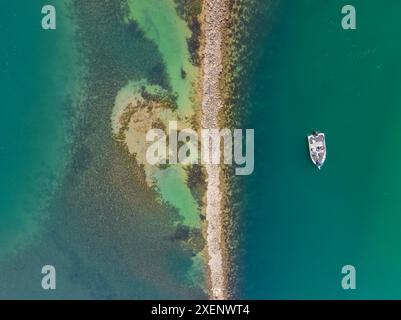 Aerial view of a small boat anchored in a calm coastal bay at Narooma on the South Coast of New Soauth Wales, Australia. Stock Photo