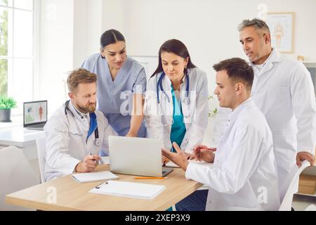 Group Of Doctors And Nurses In Hospital Meeting With Laptop Stock Photo